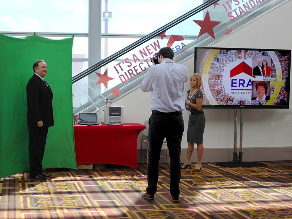 Event technician taking a guest’s photo for the ERA Realty digital mosaic at LA Live
