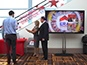 Guests admiring their printed photo takeaway from the ERA Realty at LA Live digital mosaic