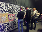Guests hand-placing printed photo tiles onto the in-progress Live Mosaic wall at the Lidl Conference in Dublin