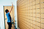 Person preparing the wall for a photo mosaic installation