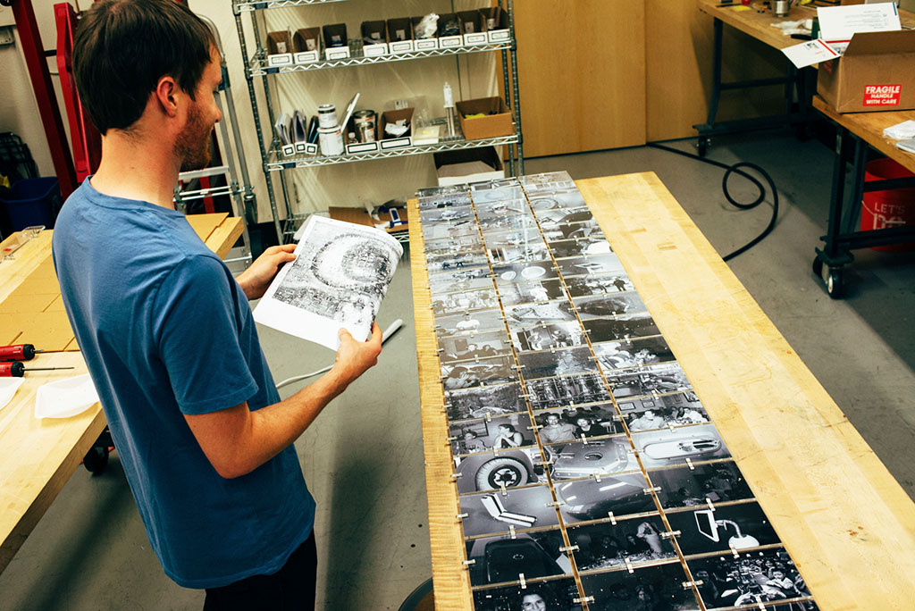 Person looking at pieces of a photo mosaic laid out on a table