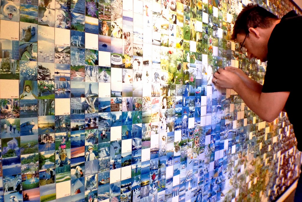 Guest positioning their photo tile on the interactive mosaic display