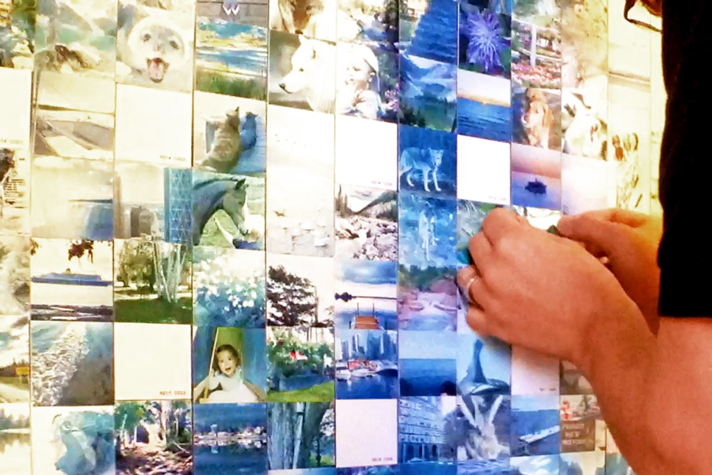 Detailed view of a guest placing a photo tile onto the Intel mosaic wall