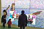 Family viewing the interactive mosaic wall with popping photo animation