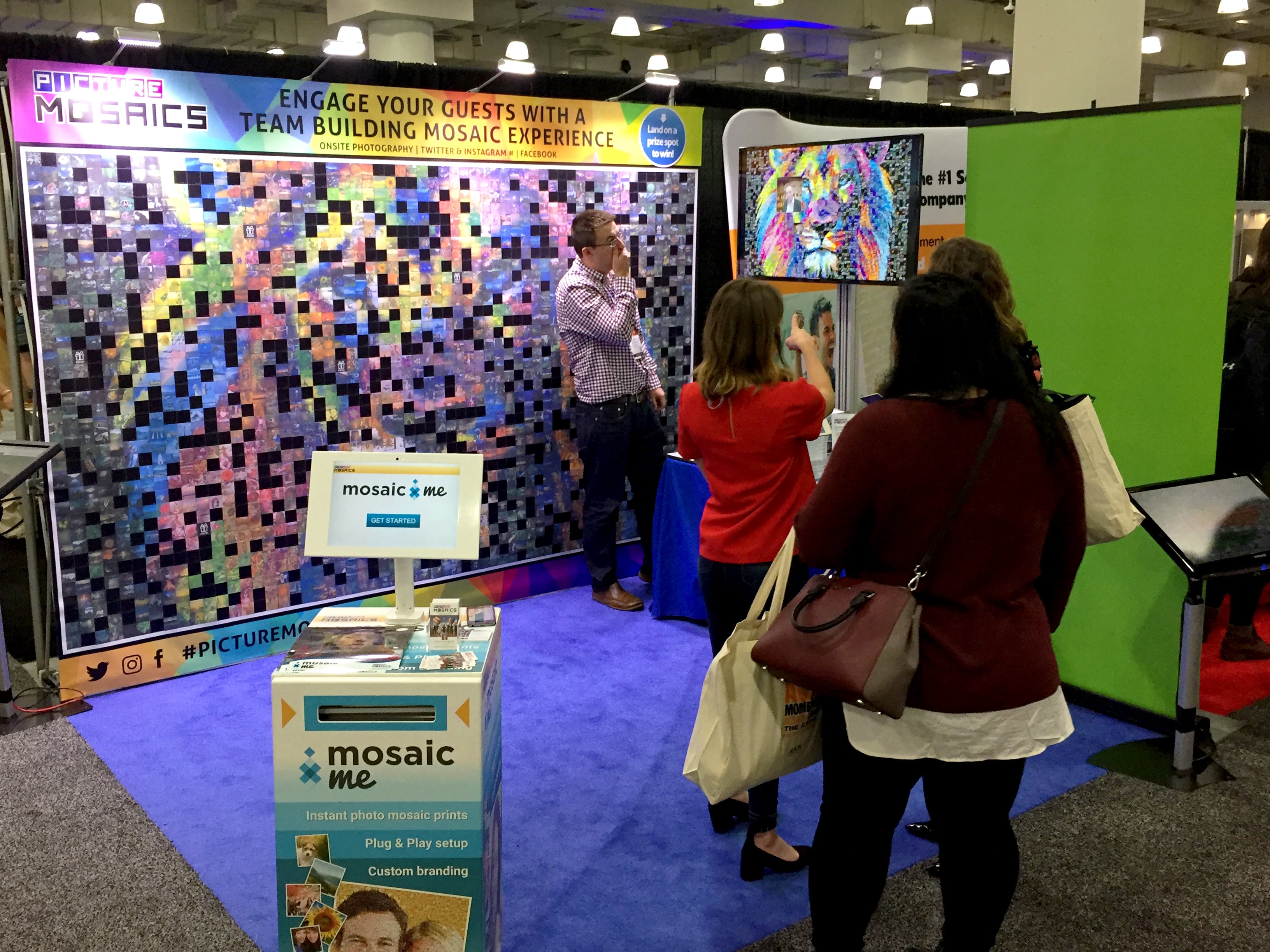 Guest attaching her photo tile to the mosaic wall display