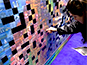 Guest adding her printed photo to the live photo mosaic wall