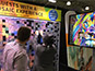 Guest placing their printed photo tile onto the interactive mosaic wall