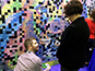 vent staff assisting guest with photo tile placement on the mosaic wall