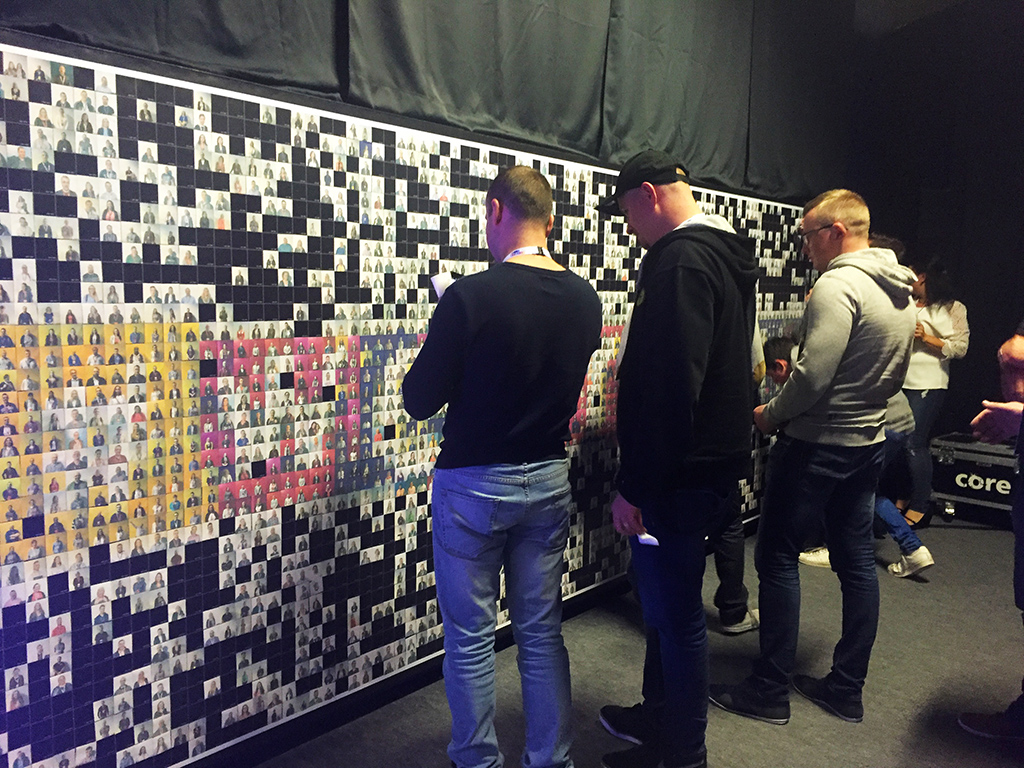 Guests hand-placing printed photo tiles onto the in-progress Live Mosaic wall at the Lidl Conference in Dublin