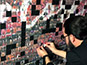 Close-up of a guest placing their photo sticker onto the photo mosaic wall