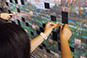 Close-up shot of a guest placing their photo into the Texas Longhorn Orange-White Spring Game Live Print Mosaic
