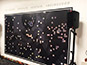 Partial mosaic in progress at the Tarkett event, showcasing several photo tiles placed on the grid