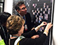 Guest placing their printed photo tile onto the Tarkett mosaic wall