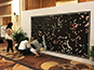 Attendee placing photo tile on mosaic wall at CosmoProf Las Vegas 2017