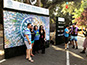 Guests posing in front of the completed mosaic wall at Camp Mars