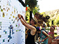 Guest placing their photo tile onto the mosaic wall during Camp Mars event