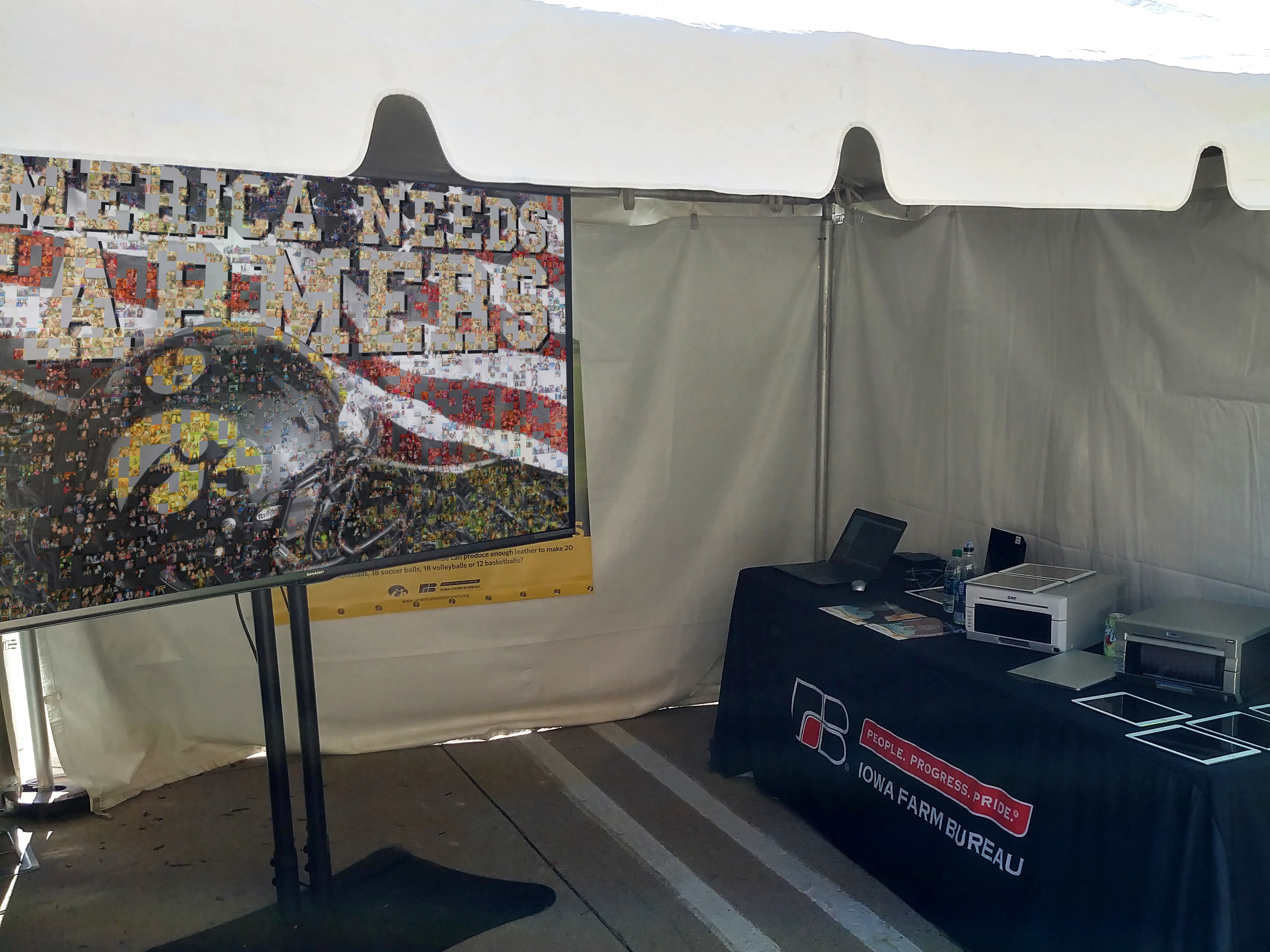 Digital mosaic display setup under a branded event tent