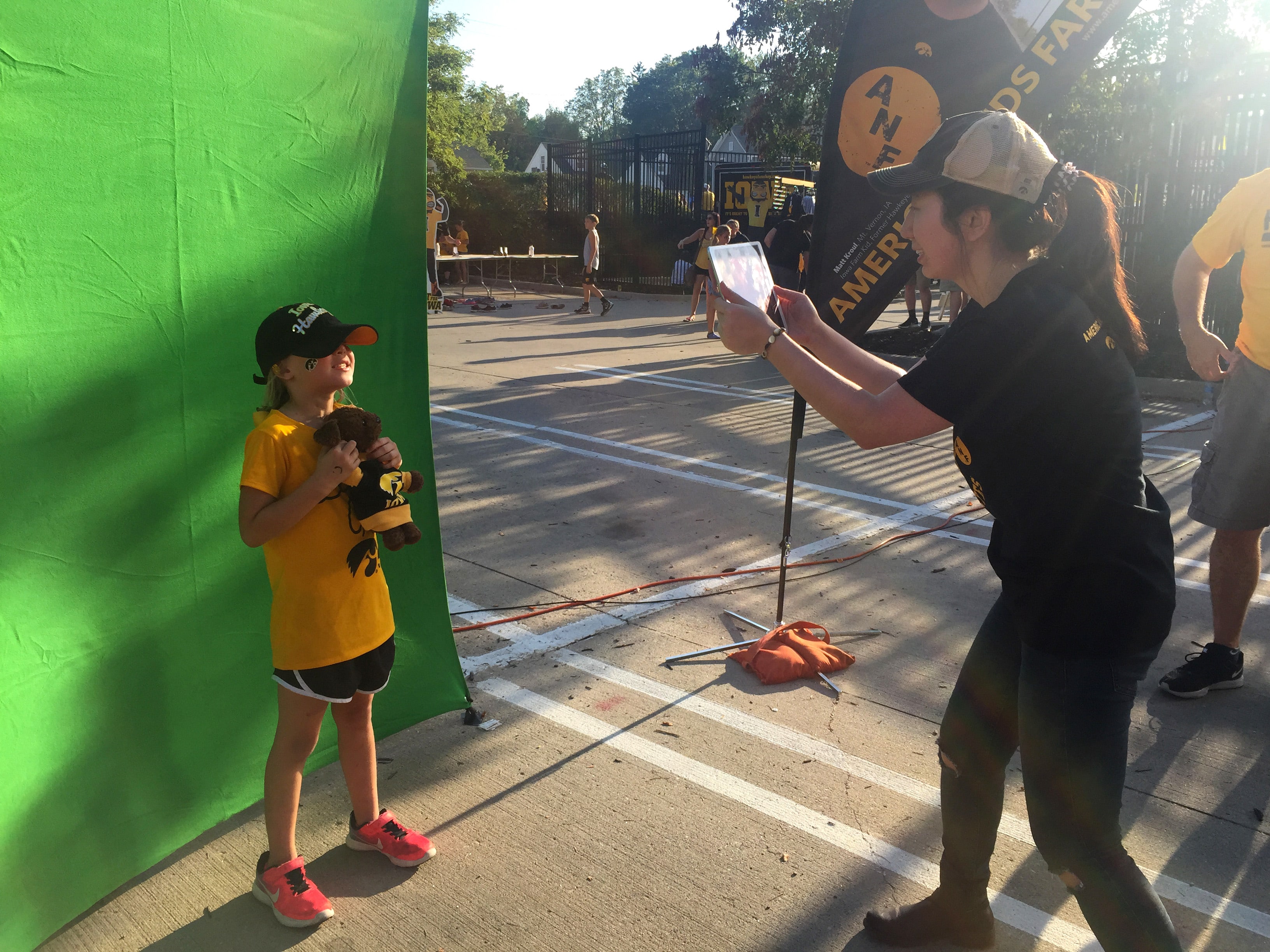 Young Iowa fan getting their photo taken by event tech for the mosaic