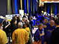 Event attendees gathered with the mosaic wall in the background