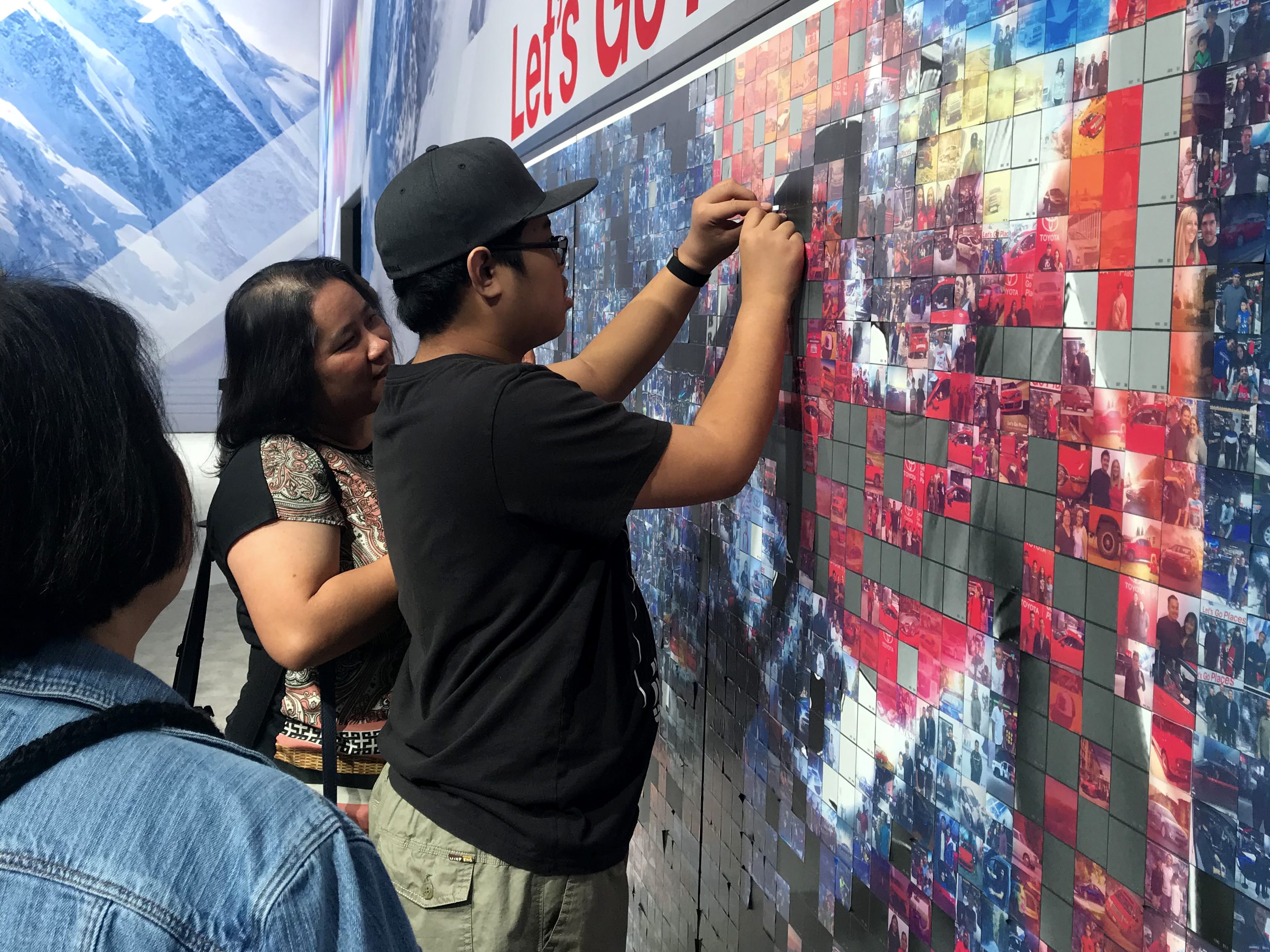 Guests placing printed photo tiles onto the collaborative Toyota mosaic