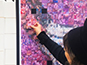 Guest placing their printed photo tile onto the interactive mosaic wall