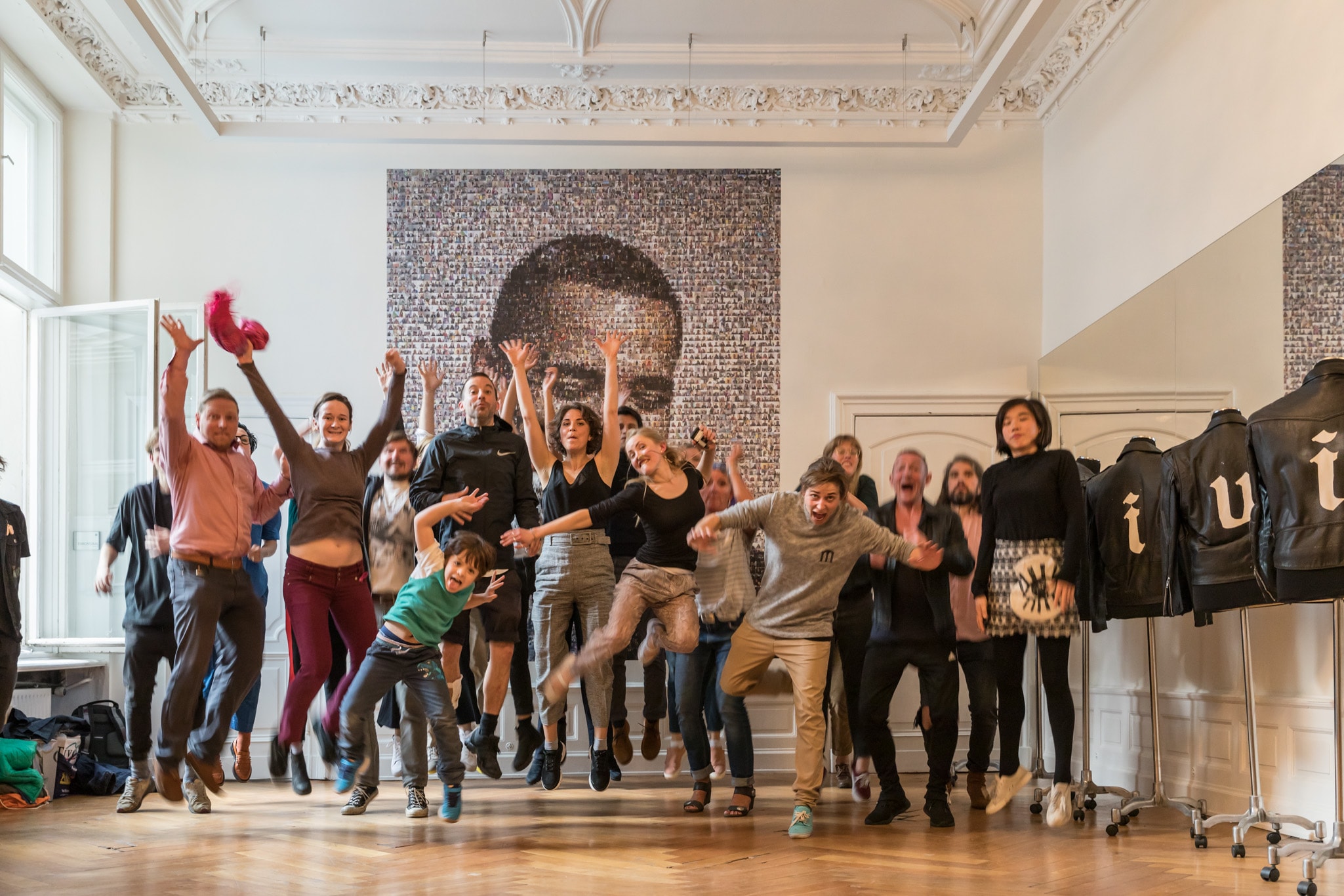 Employees and their families celebrating in front of the photo mosaic installation