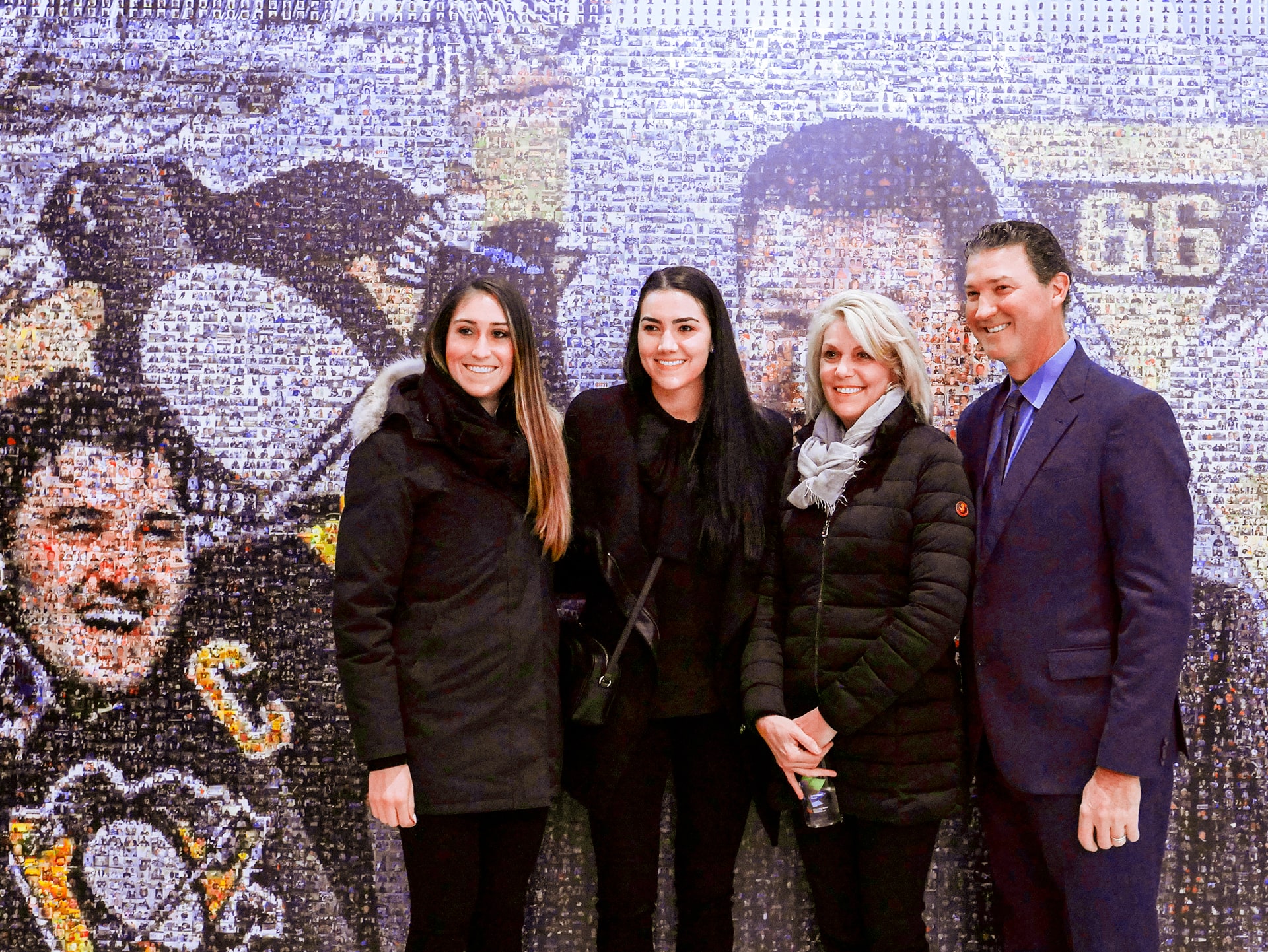 The Lemieux family poses in front of the interactive Mario Mosaic 2.0 experience.