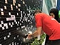 Thumbnail of volunteer helping place a photo during the 2019 Special Olympics World Games mosaic activation.