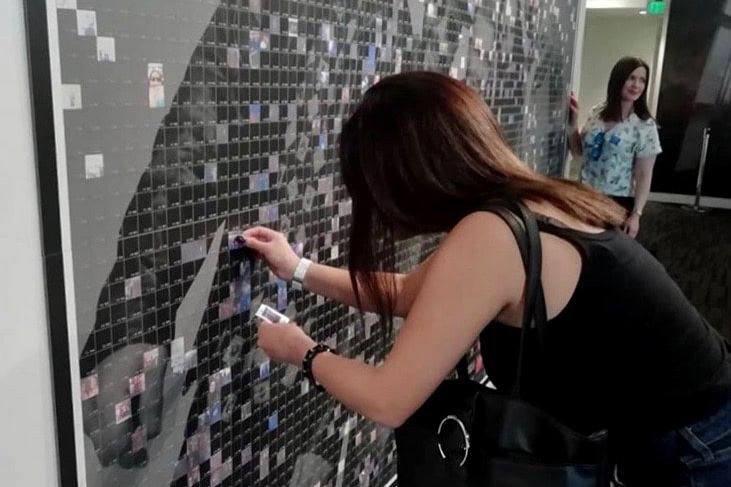 Backstreet Boys: The Experience – Fan interacting with the mosaic wall at the exhibit.