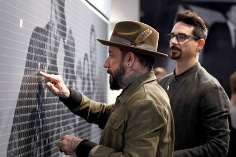 Backstreet Boys: The Experience – AJ McLean placing a fan photo onto the mosaic wall.
