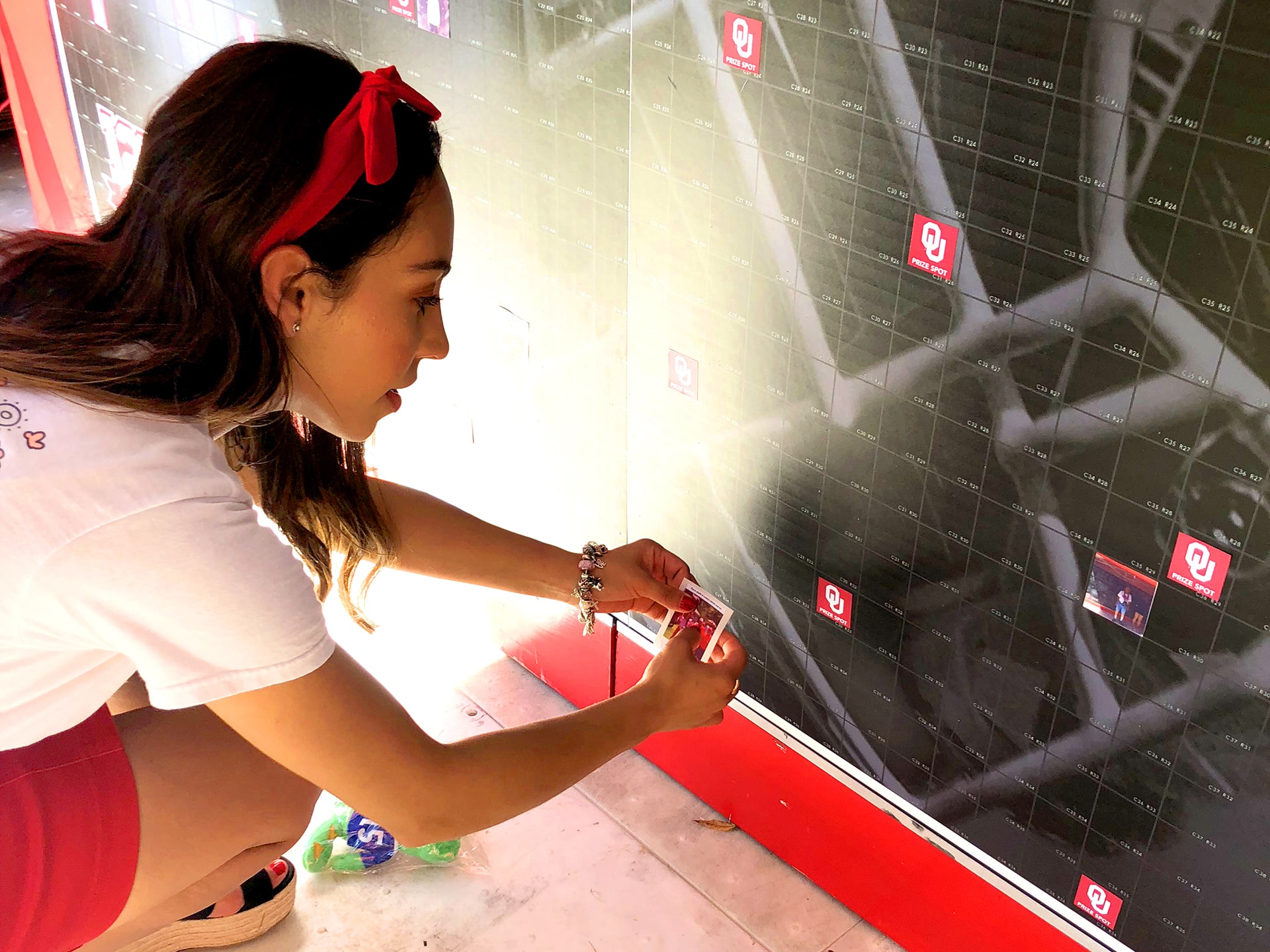 Guest placing her personalized photo tile into the interactive mosaic wall