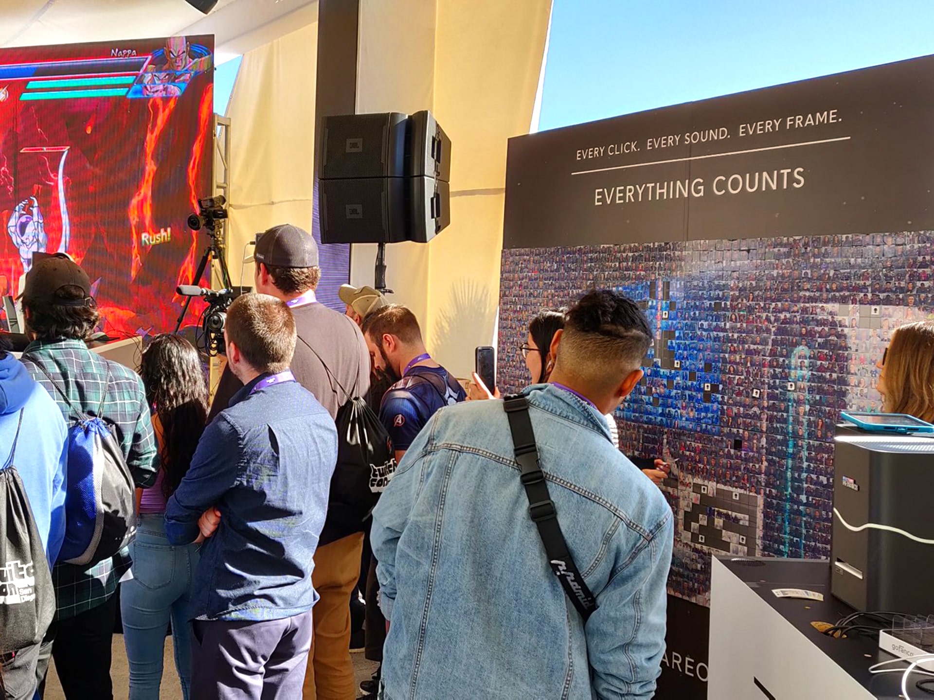 Guest posing in front of the interactive Alienware mosaic installation