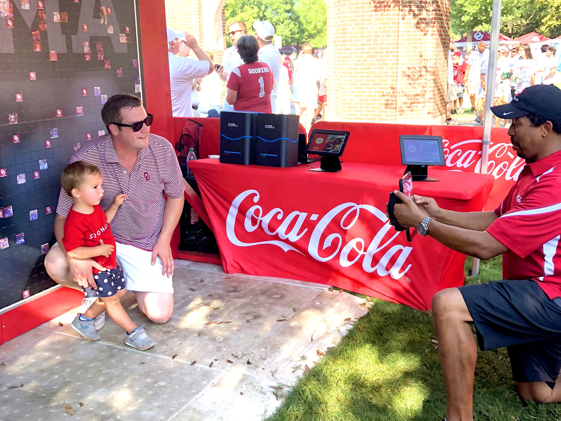 Father and son posing for a photo to be featured in the Coca-Cola mosaic wall