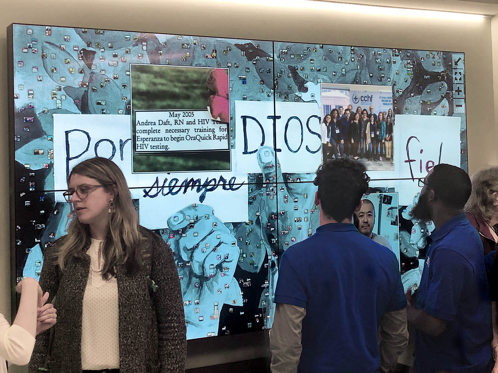Guests viewing a live digital photo mosaic on screen at Esperanza Health Center Grand Opening