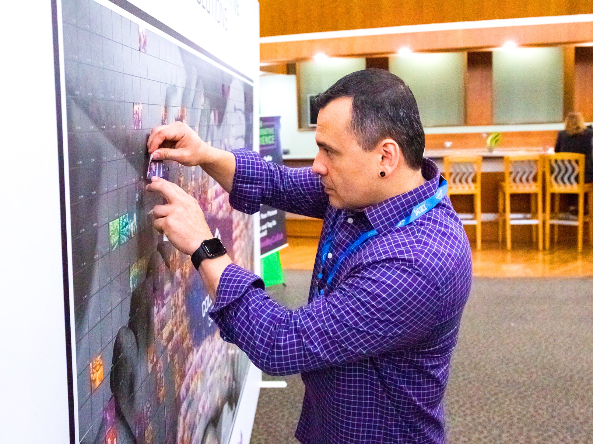 Close-up of guest adding their photo tile to the collaborative mosaic wall