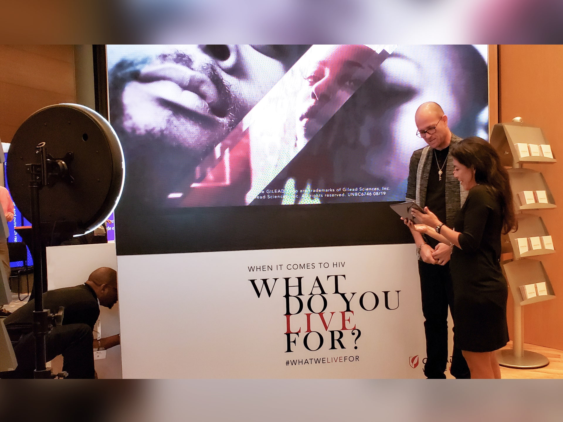 Event technician explaining the photo mosaic process to an interested guest