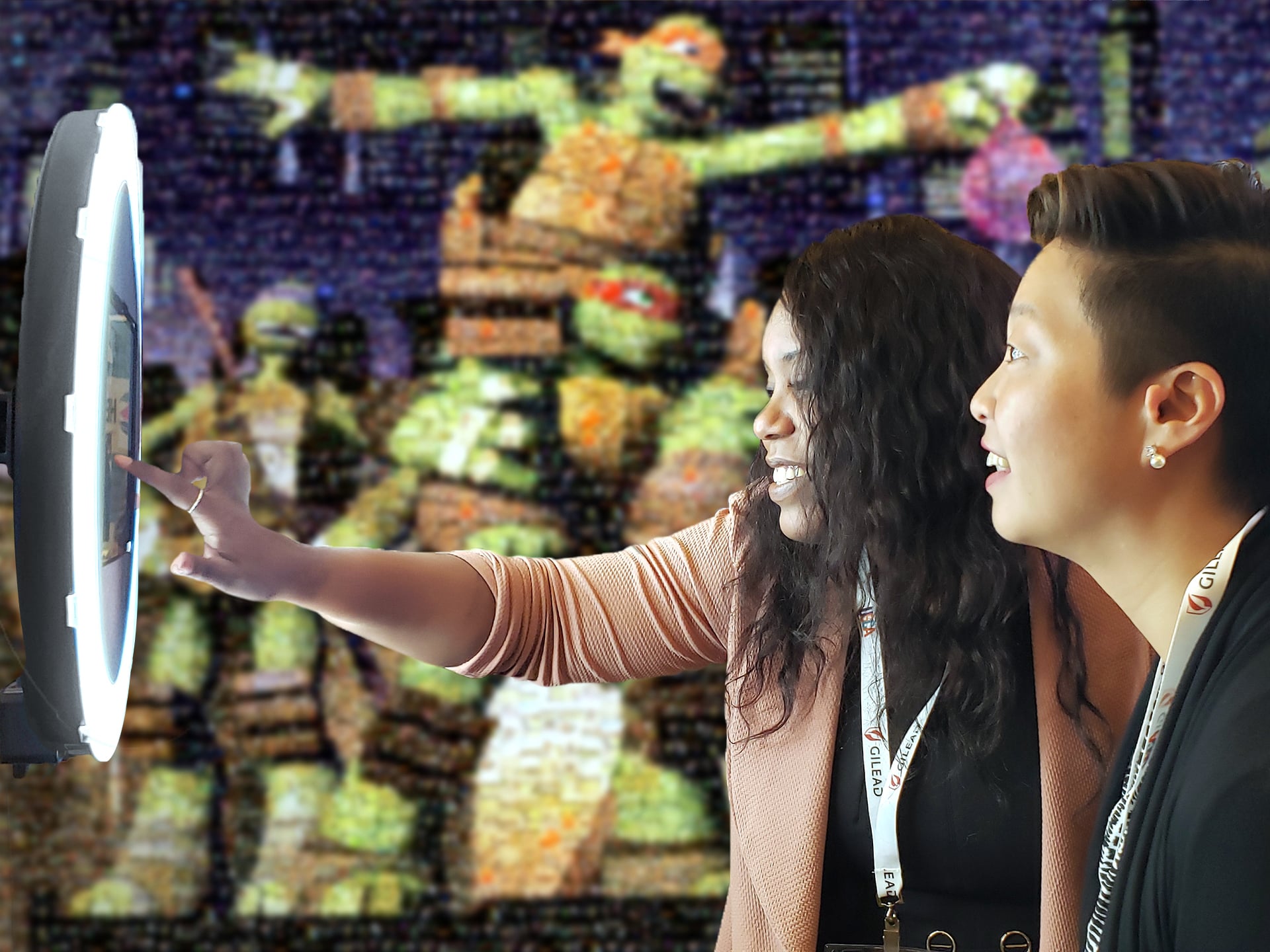 Two guests using a ringlight photobooth to submit a photo to the digital photo mosaic