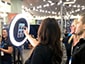 Two attendees selecting a background for their photo at iPad kiosk station