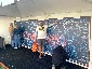 A guest pointing to their photo on the completed Super Bowl LV mosaic wall.