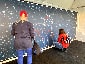A fan placing their printed photo tile onto the Super Bowl LV Live Print Mosaic wall.