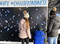 Guests viewing the completed sections of the photo mosaic wall at the event.