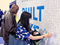 Guests observing and placing their sketches on the SketchBot mosaic wall at the Viasat booth.