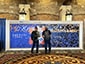 Two guests admiring the evolving SketchBot mosaic wall at live event