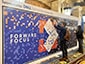Guests placing portrait tiles on the World’s Largest SketchBot Mosaic installation