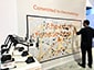 Attendee placing their portrait sketch onto the mosaic wall.