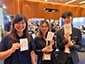 Three event guests posing with their personalized Ai SketchBot portrait sketches