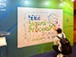 Guest adding their Ai SketchBot portrait to interactive photo mosaic wall