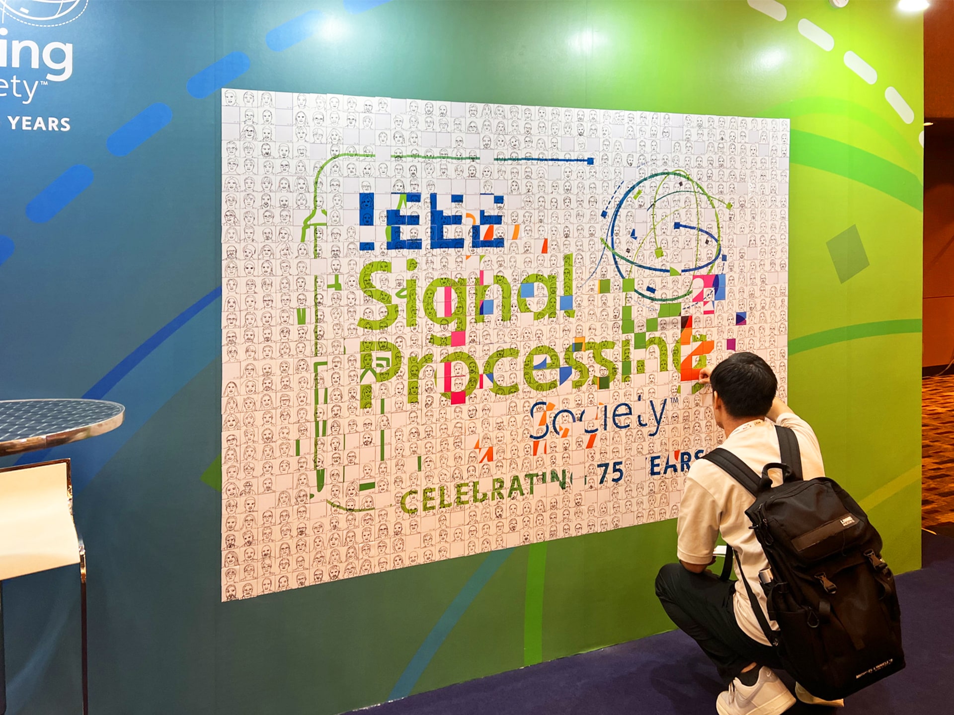 A guest placing their Ai SketchBot portrait onto the mosaic wall