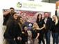 Collaborative Solutions team posing in front of branded photo mosaic wall