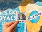 Guest holding up their printed tile with coordinates, a vibrant photo mosaic wall in the background